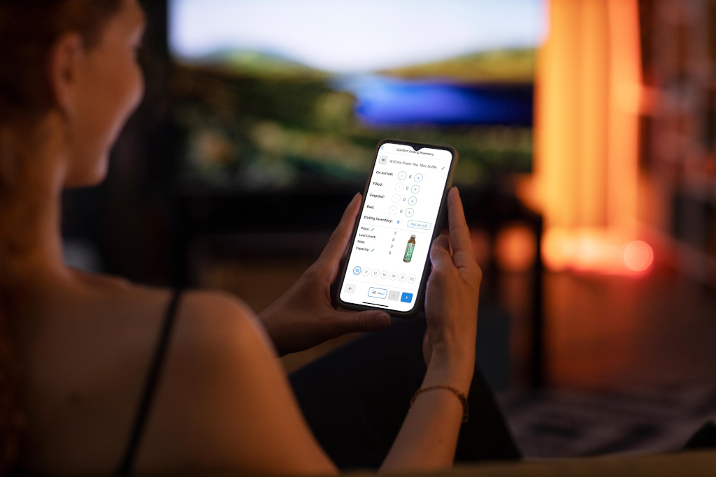 Person using the VendSoft mobile app on a smartphone in a home setting
